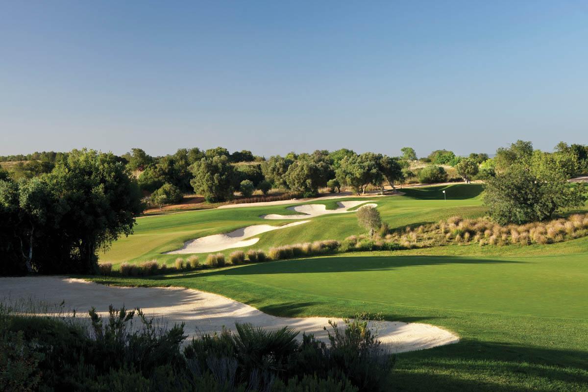 Winding fairway flanked by bunkers leading to the green