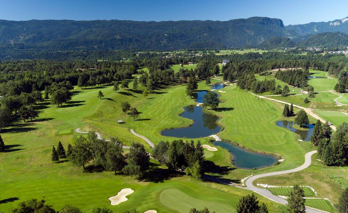 Aerial view of a golf course with winding water hazards and tree-lined fairways.