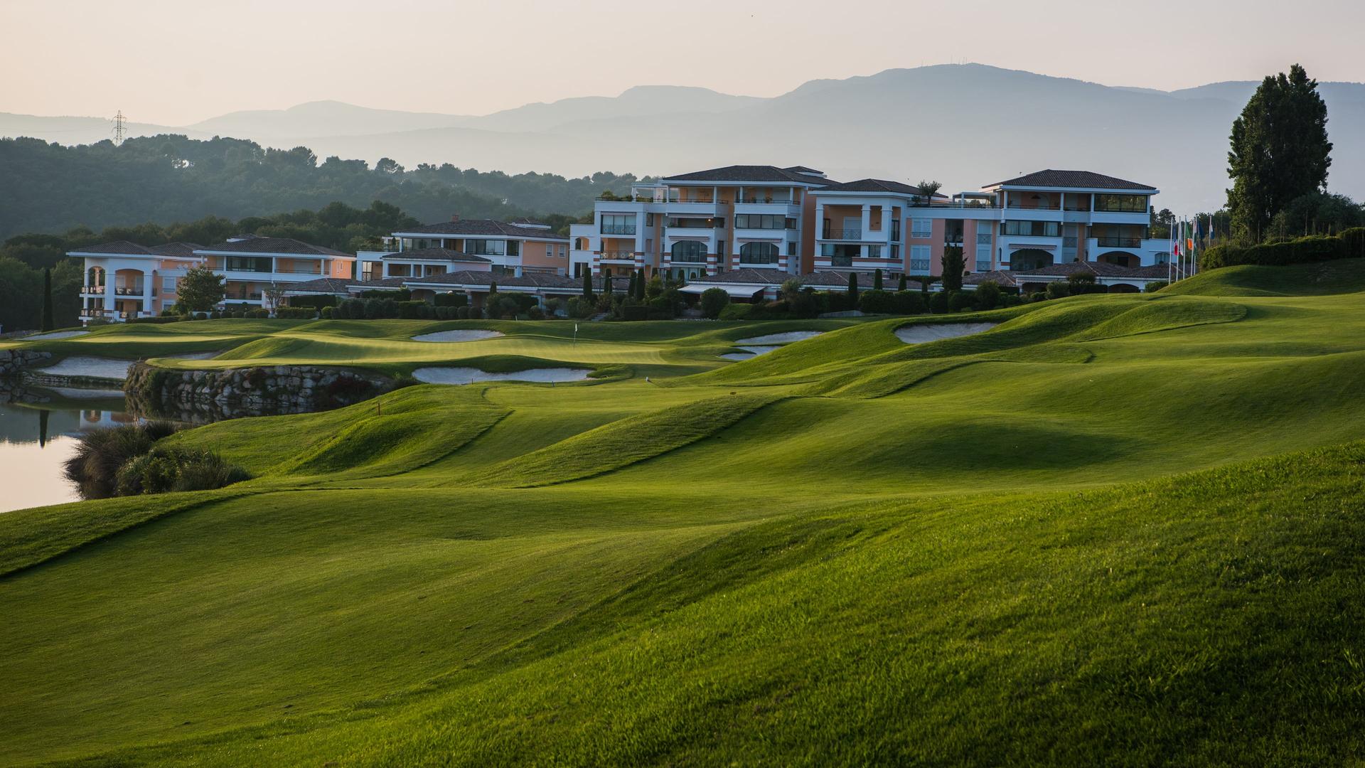Undulating fairway leading to a sloping green with the hotel in the background