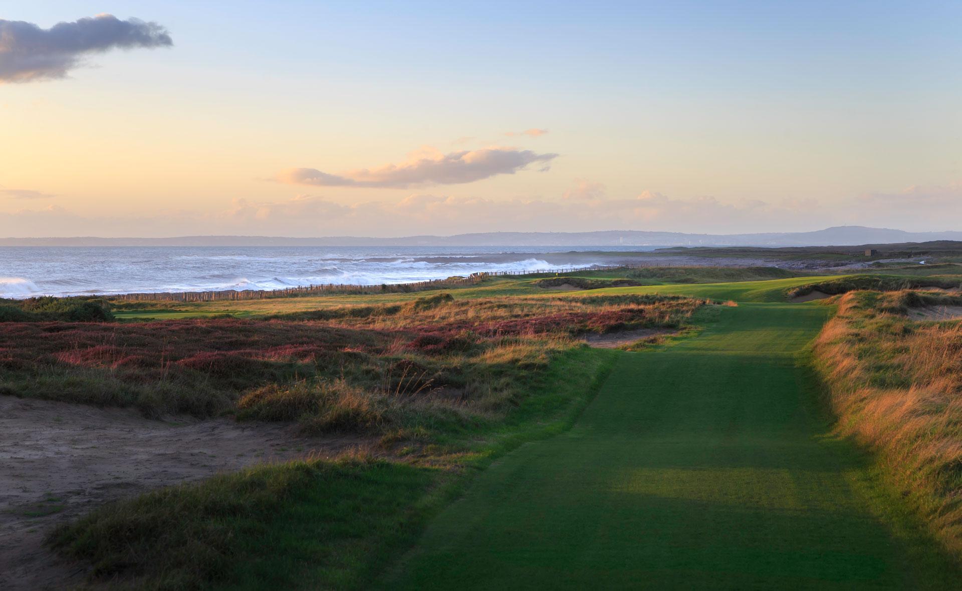 Lush fairways with blue skies and a beautiful view of the sea