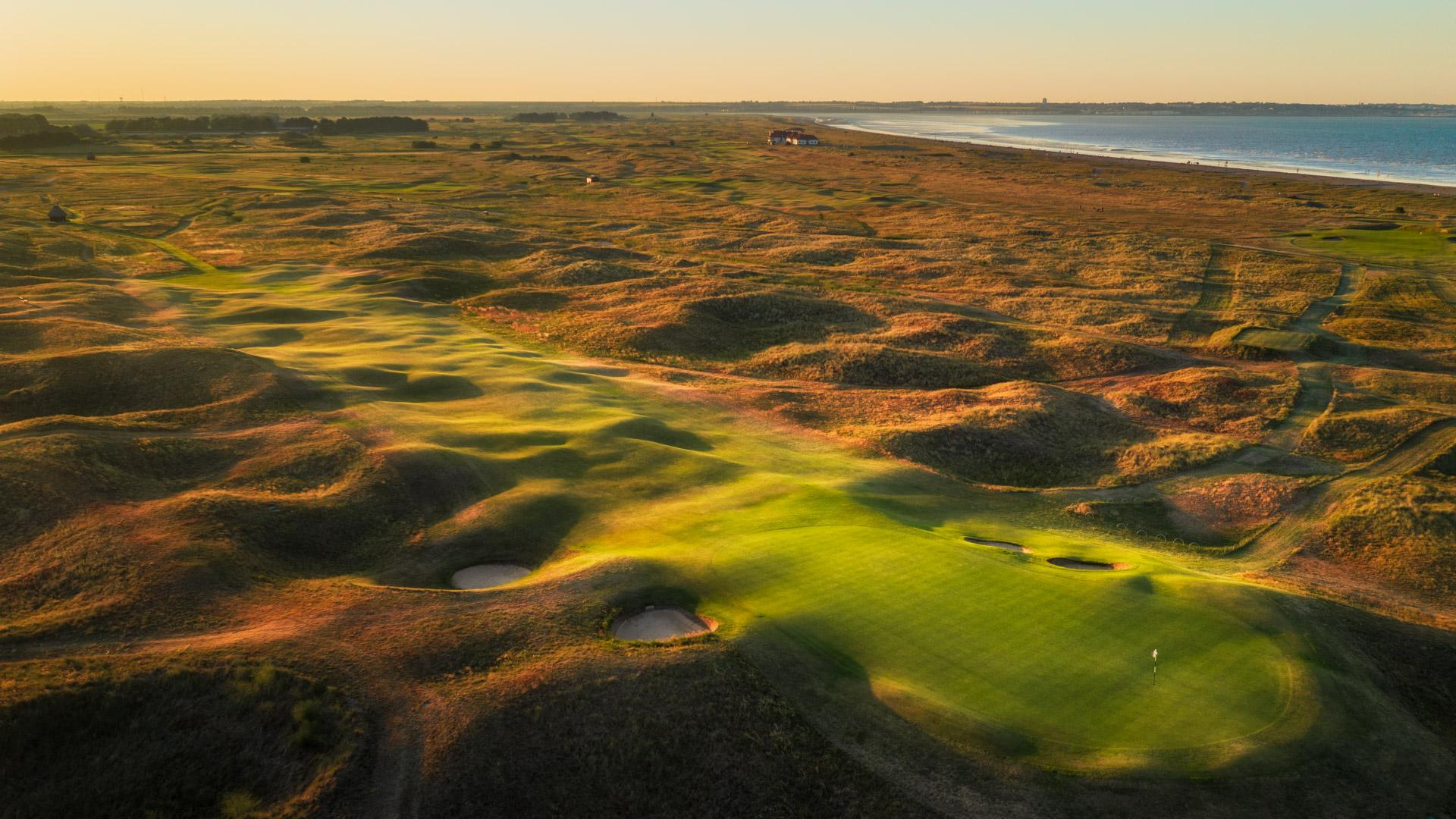 Birds eye view of the well-maintained green surrounded by sand bunkers and rolling dunes