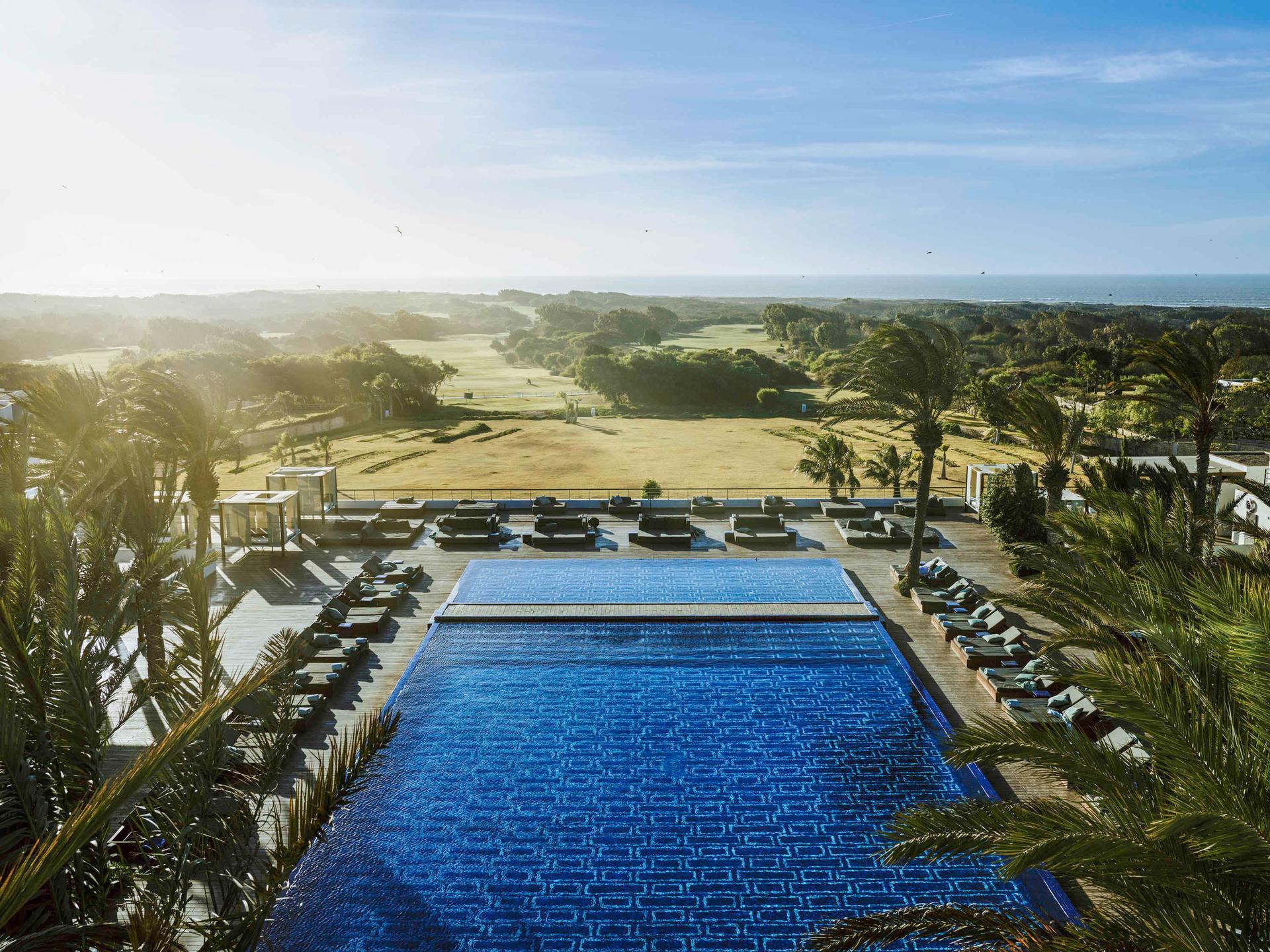 Overhead view of the sun setting over the Sofitel Essaouira Mogador Golf & Spa swimming pool