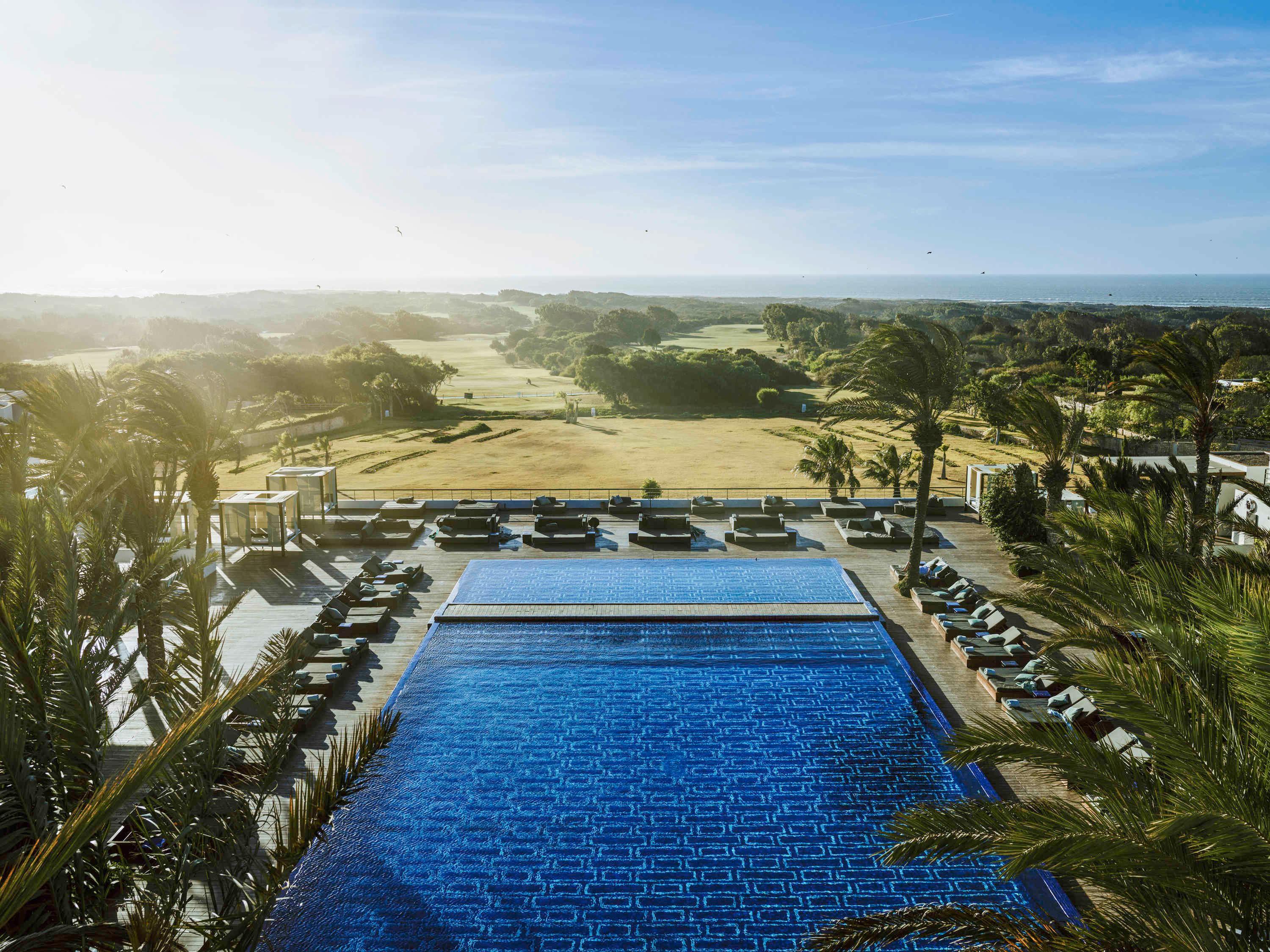 Overhead view of the sun setting over the Sofitel Essaouira Mogador Golf & Spa swimming pool