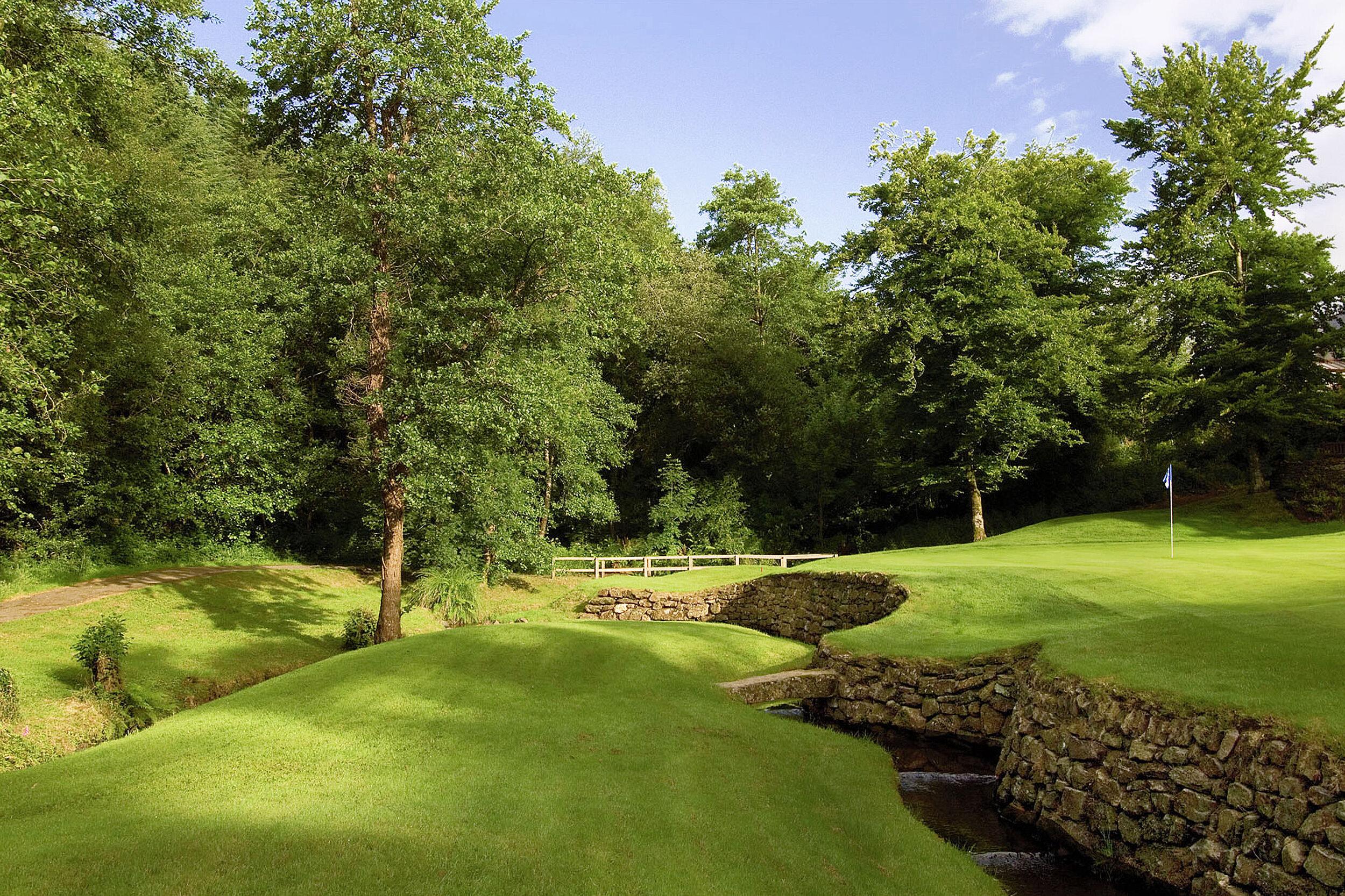 Rock wall elevating the green from water feature separating the course