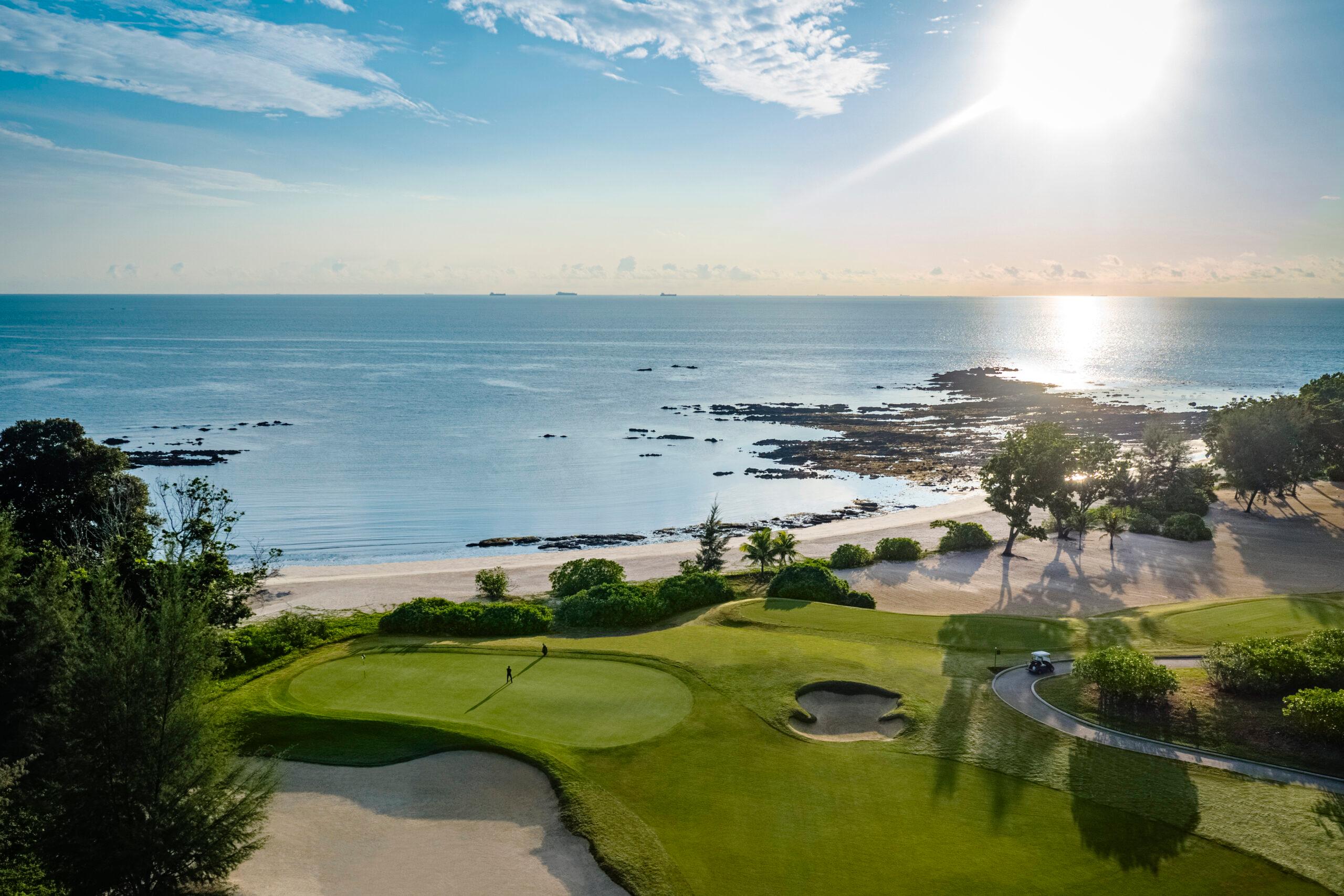 A scenic seaside golf hole with stunning ocean views at sunrise.