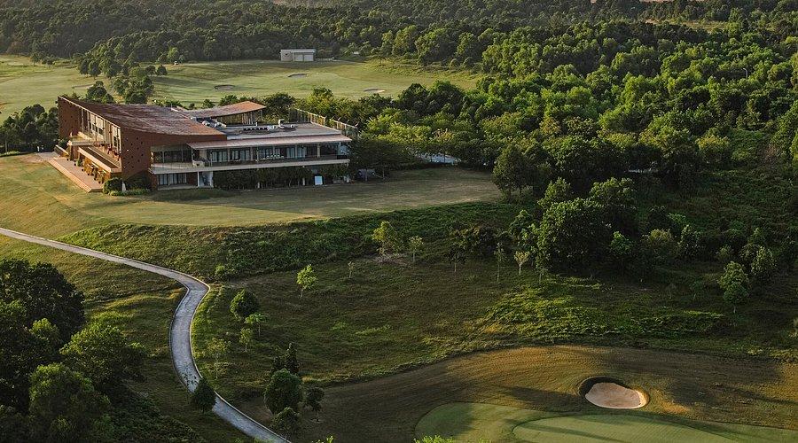 A modern golf clubhouse overlooking expansive green fairways.
