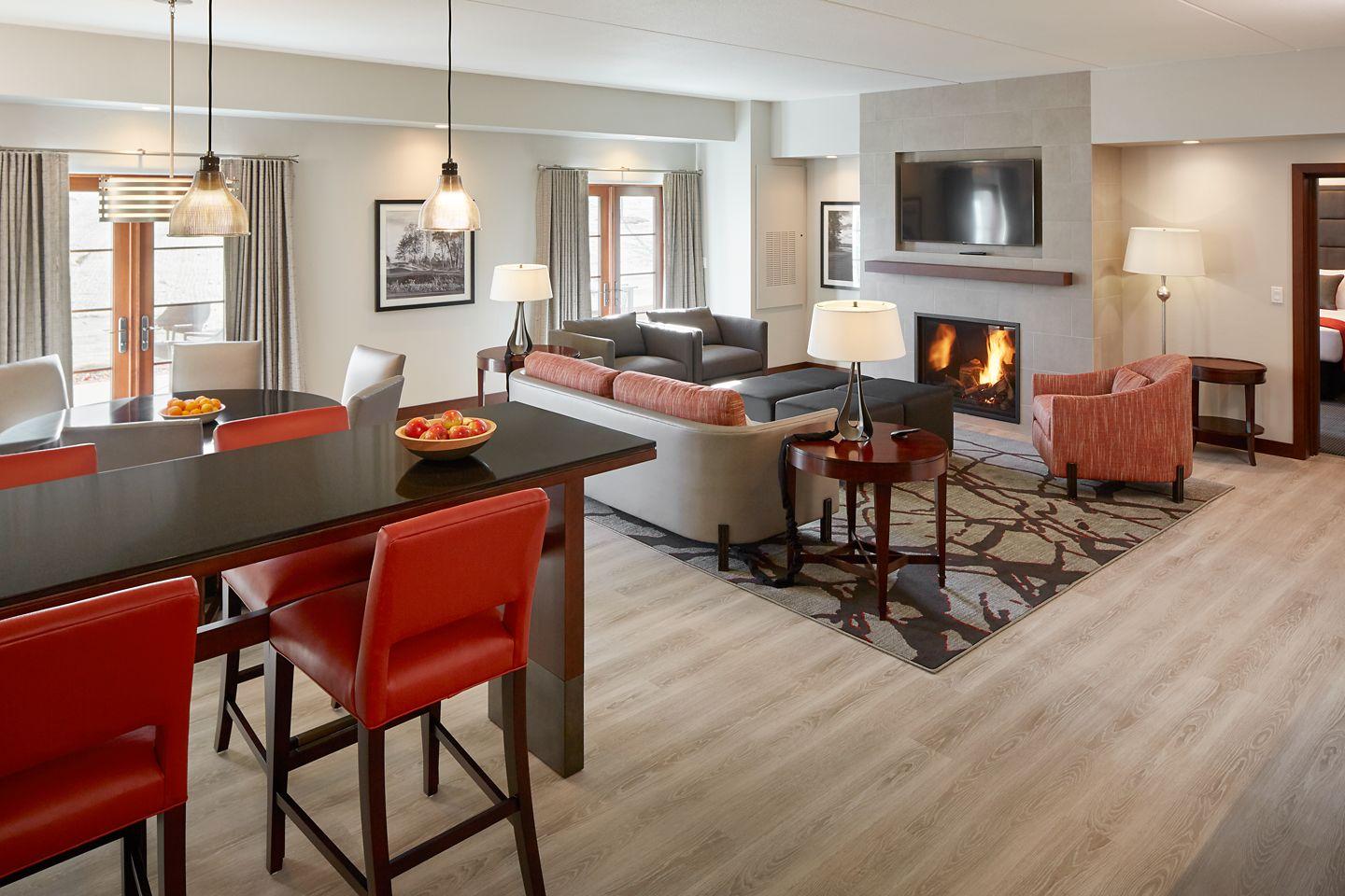A spacious suite with a living area, fireplace, and dining space.