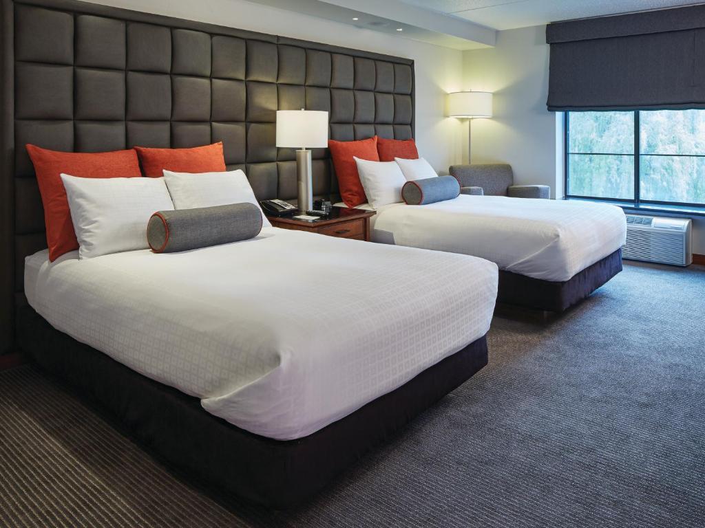 A cozy hotel room with two double beds and modern decor.