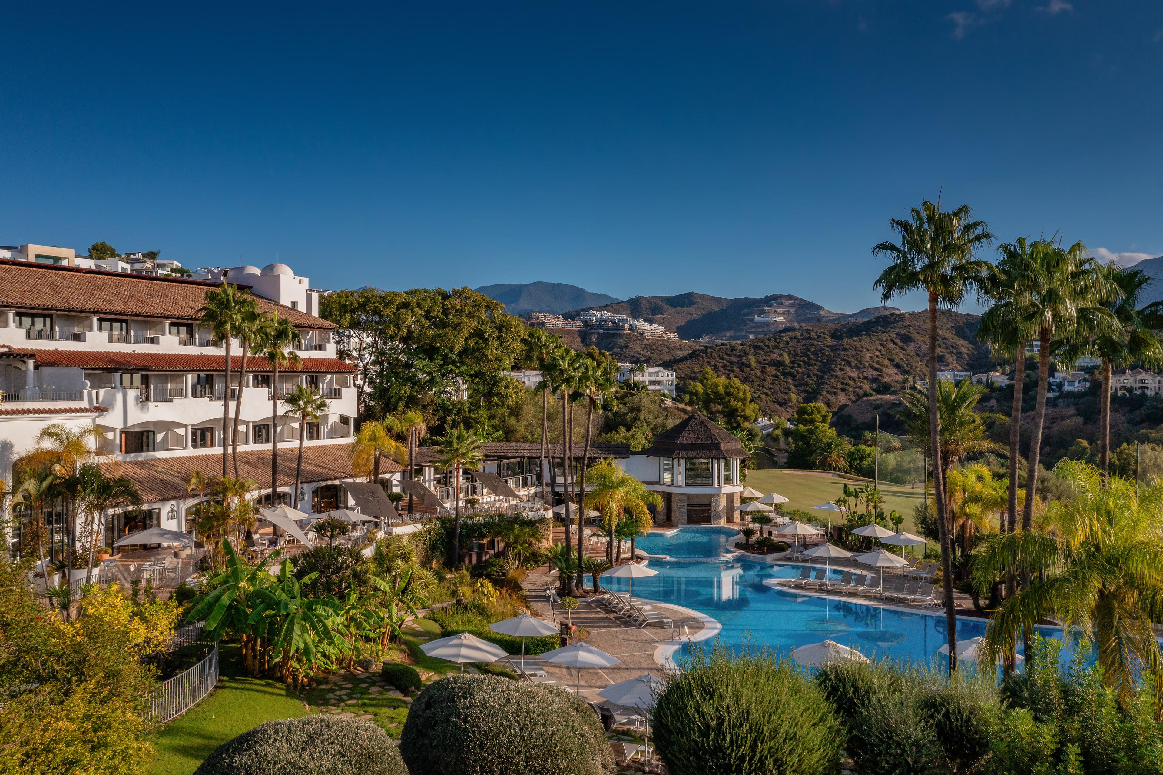 View of the hotel and swimming pool with mountains in the background