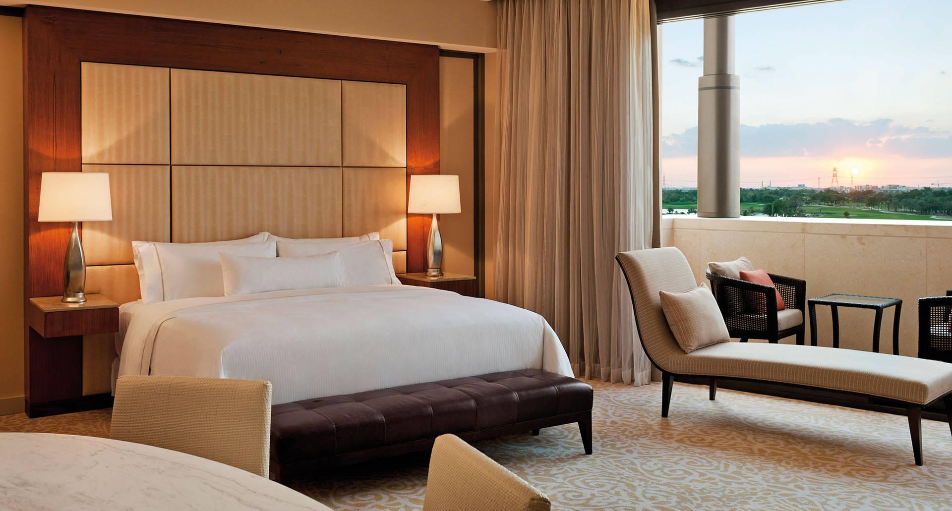 A double bed room at the resort with balcony views of the sun setting in the distance