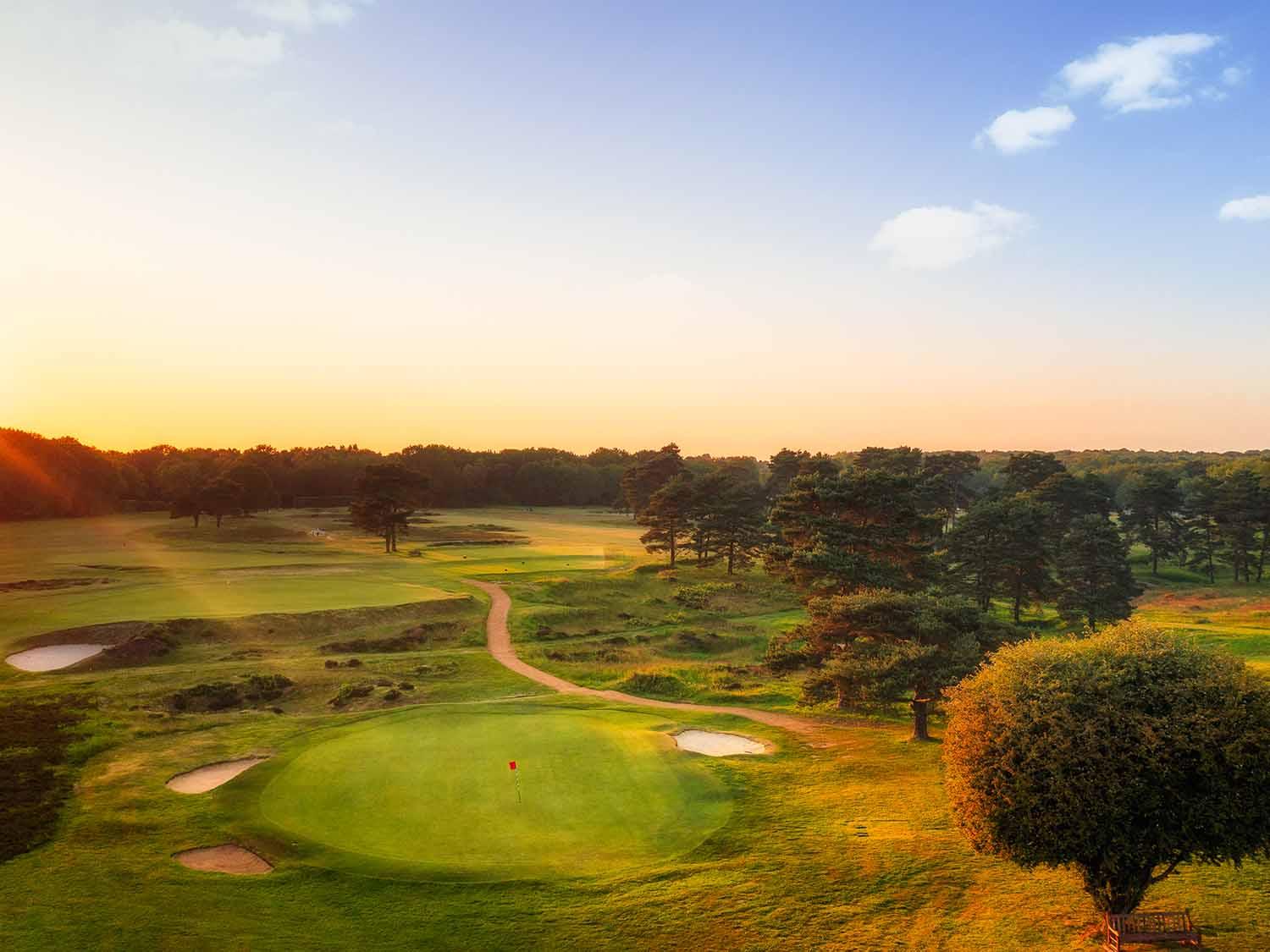 Golden sun setting over the well-maintained green at the Walton Heath Course