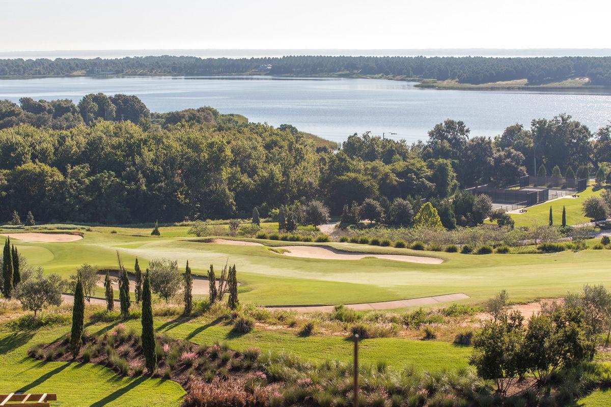 Birdseye view of a well maintained fairway nestled with sand bunkers with coastal views