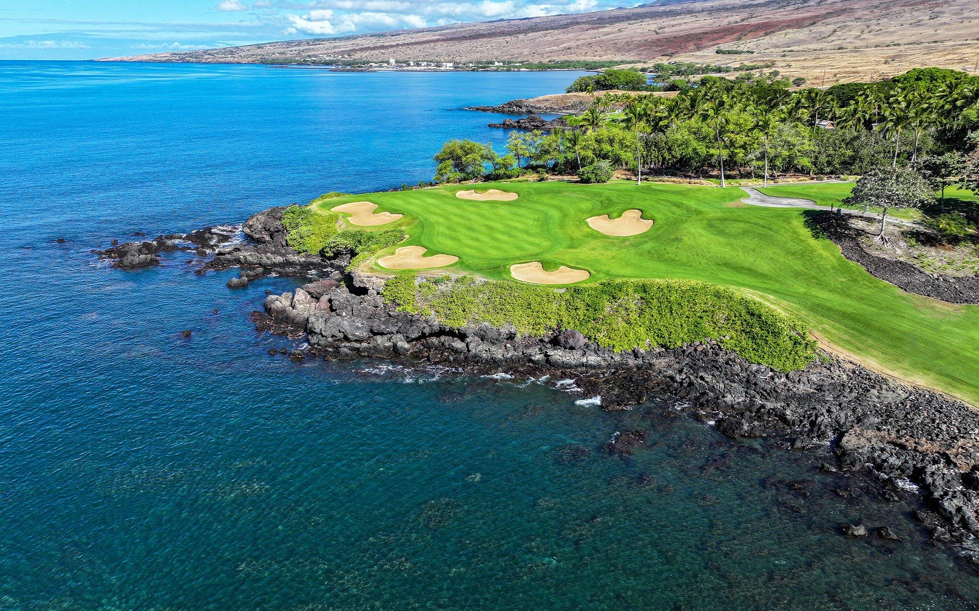 Aerial view of a cliffside green with sea views