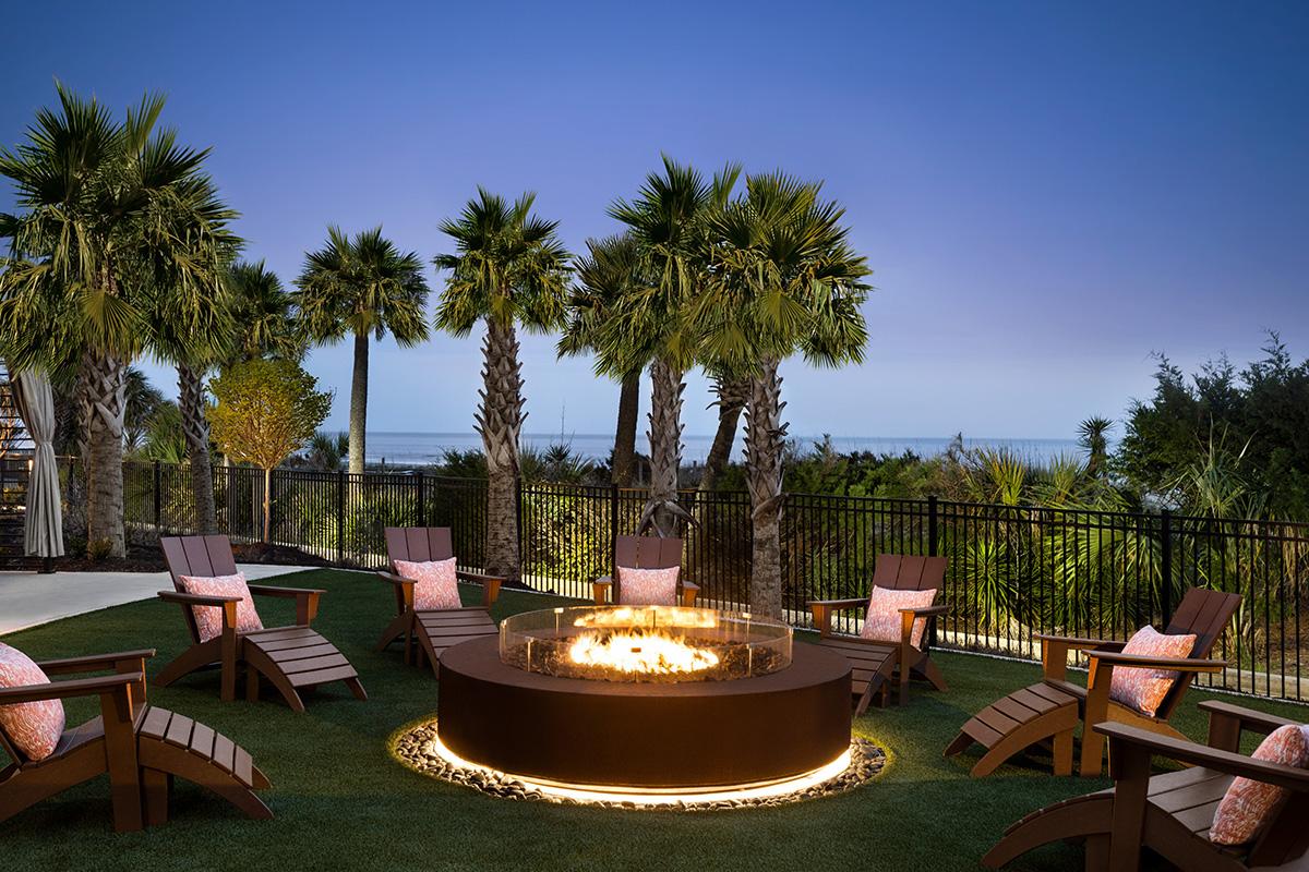 An outdoor fireplace with surrounding chairs