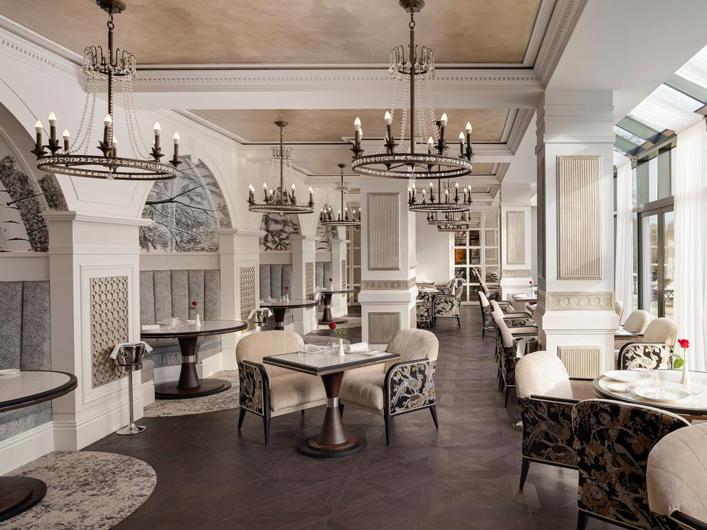 Dining room at the hotel with grand pillars, chandlers and a large panoramic window for natural light