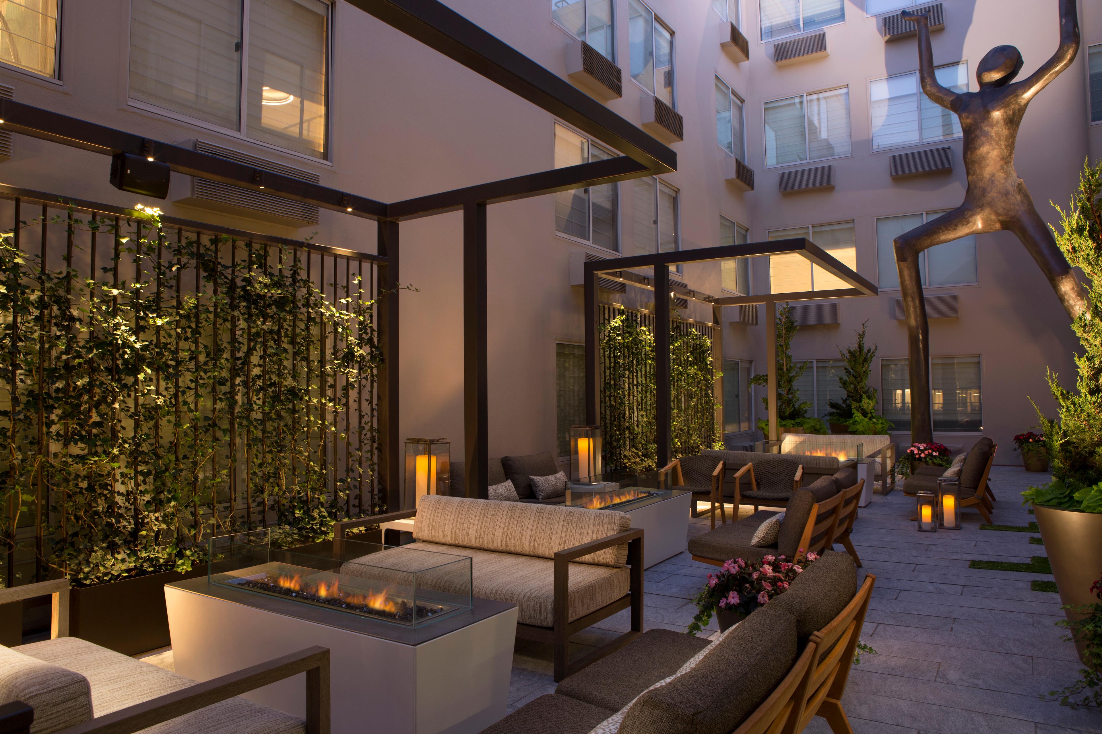 Outdoor seating area at the hotel with a statue that appears to be holding up something