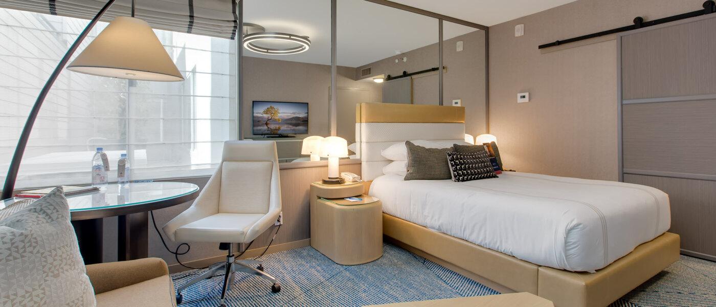 Single bed room at the hotel with a mirror behind the headboard following a modern design