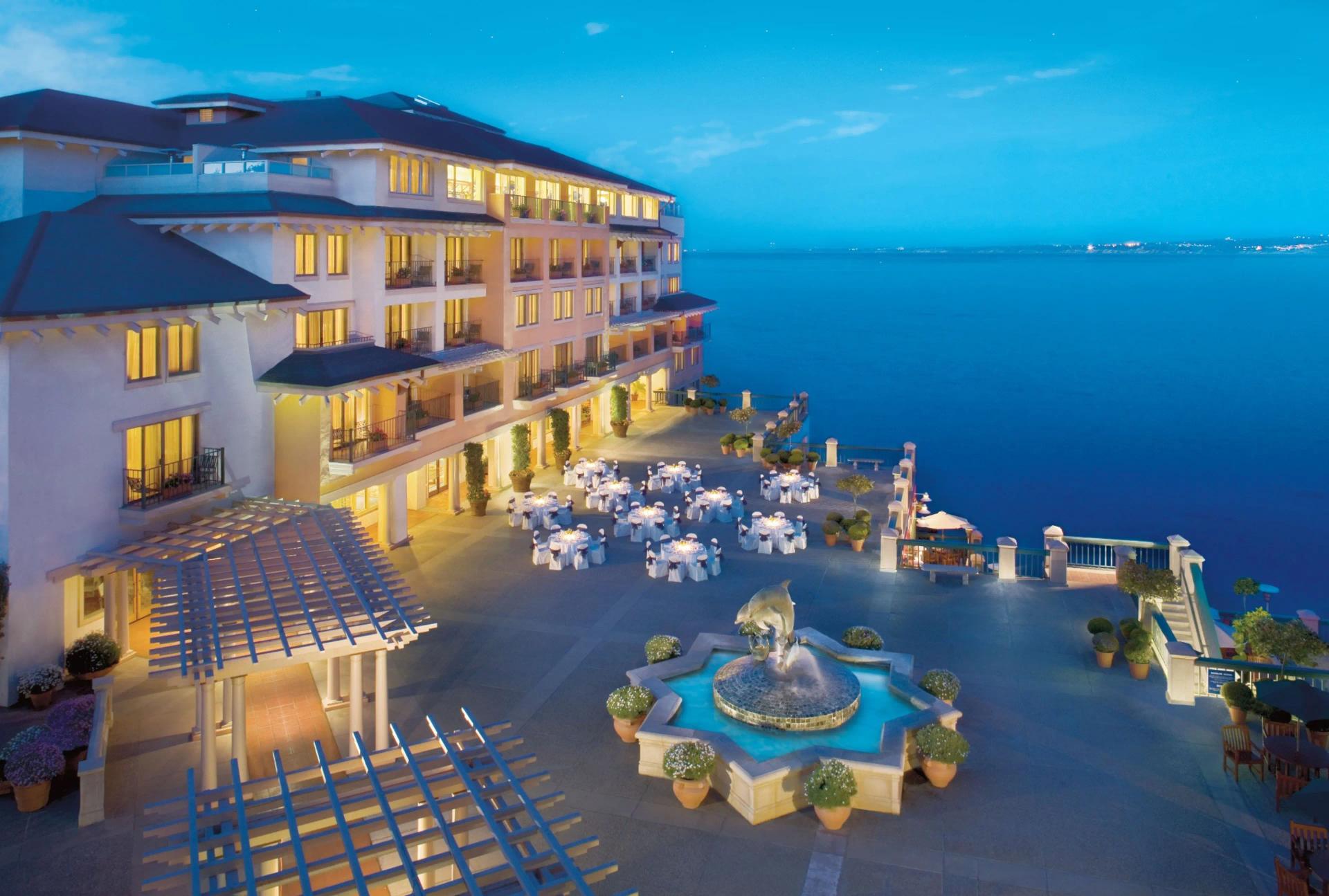 Overhead view of the hotel being lit up at evening with ocean views