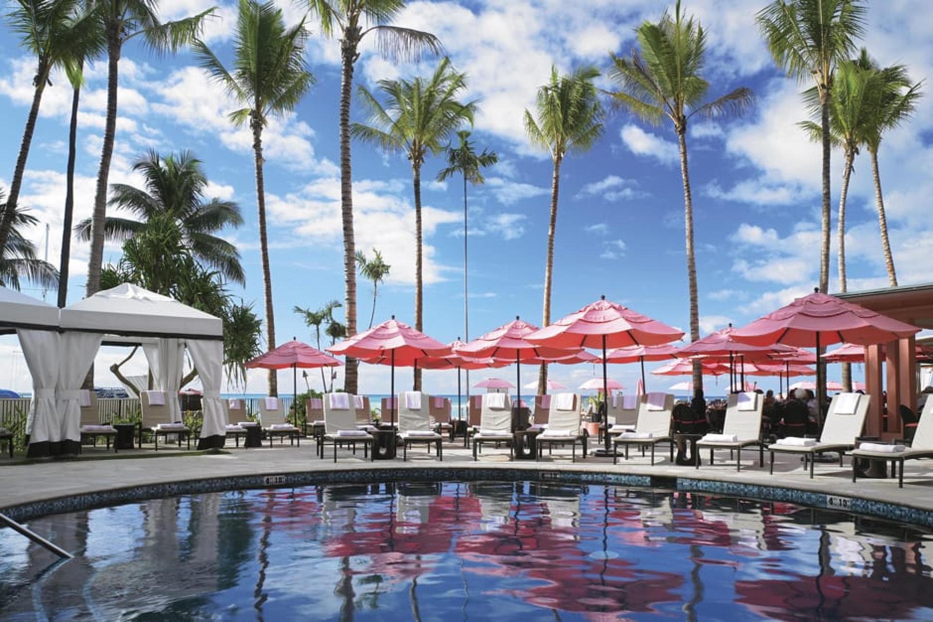 Outdoor swimming pool at the hotel surrounded by sunbeds and umbrellas