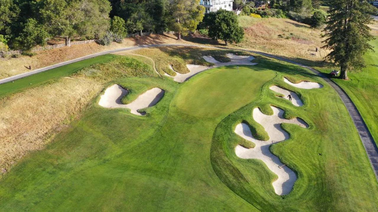 A well maintained fairway leading to a smooth green surrounded by sand bunkers