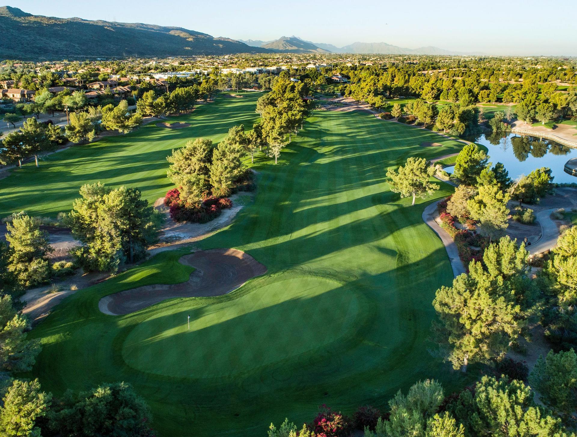 A manicured fairway leading to a smooth green next to a fairway