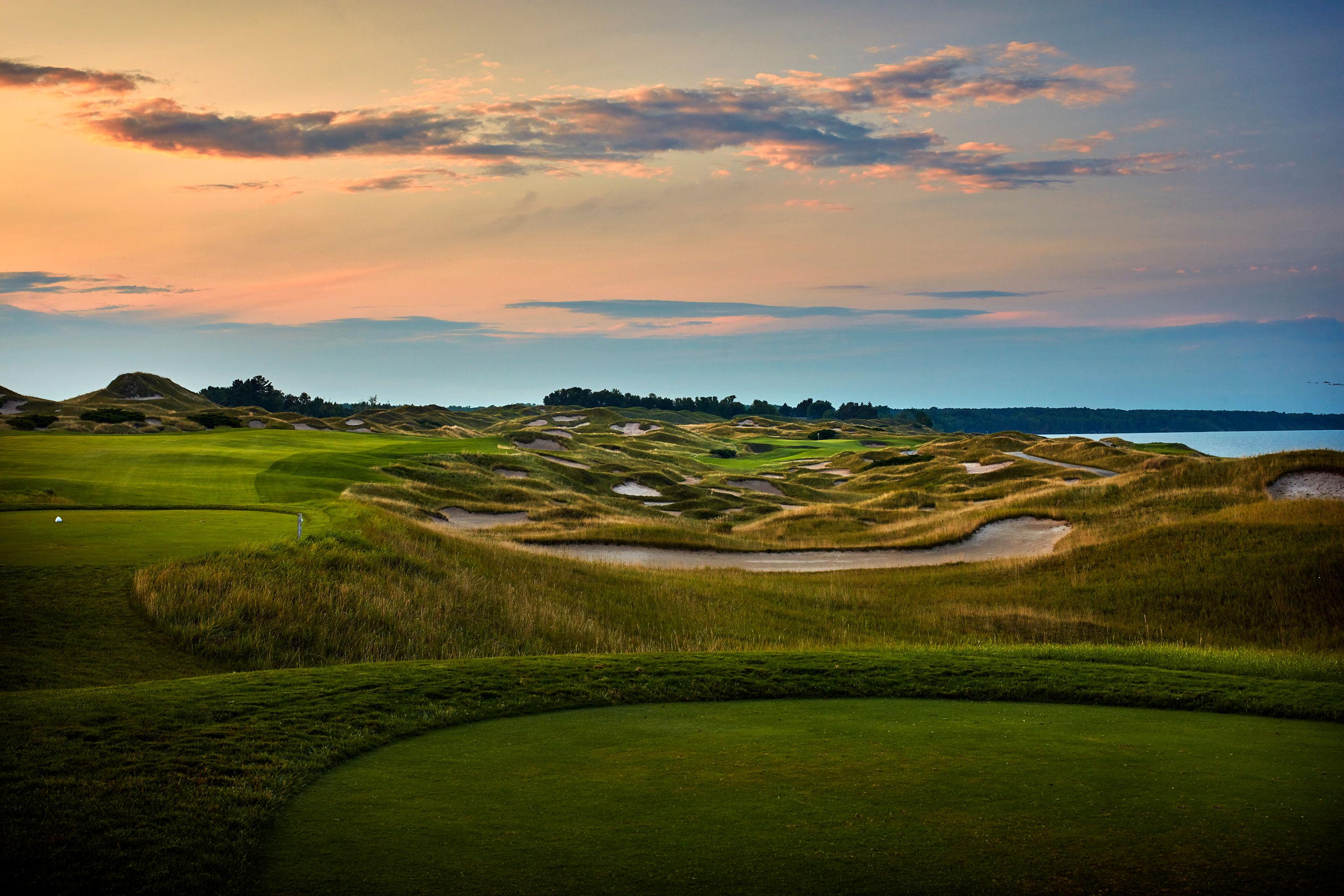 Panoramic view of a fairway littered with sand bunkers